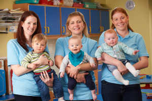 Group Of Workers With Babies In Nursery